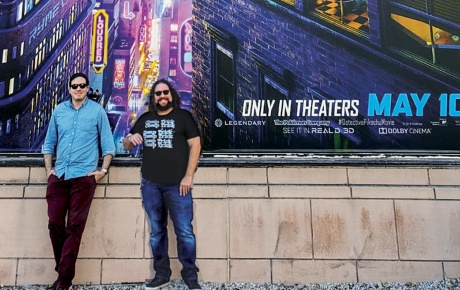 Dan Hernandez &rsquo;06 and Benji Samit &rsquo;06 standing in front of a Pok&eacute;mon: Detective Pikachu poster