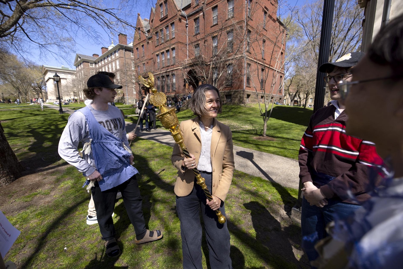Image of associate professor of archaeology and Egyptology and Assyriology Laurel Bestock holding an ancient staff on the green.