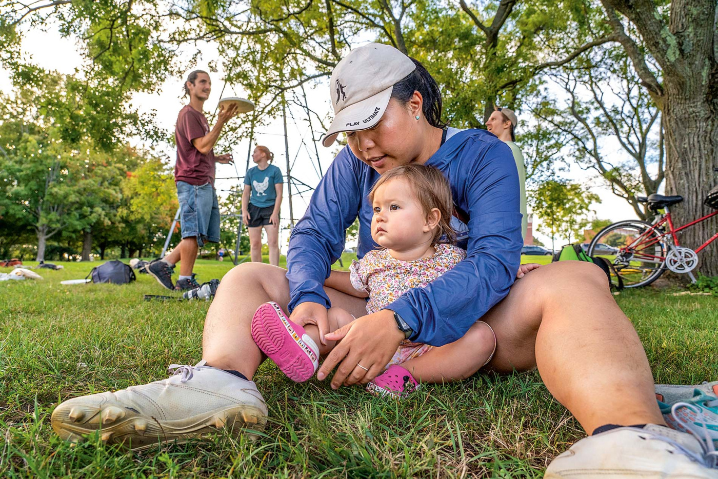 Image of a mother sitting on the ground with her baby in front of her